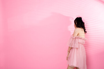 Portrait of Asian girl wear pink dress over pink tone background