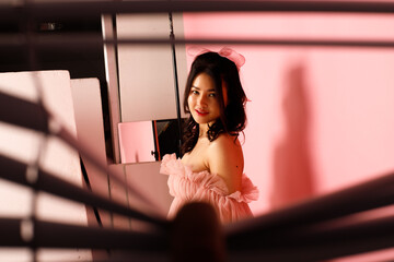 Portrait of Asian girl wear pink dress over pink tone background
