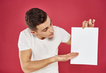 Man with a flyer in his hand on a red background advertising mockup