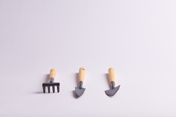 three shovels and a rake for planting seeds in pots