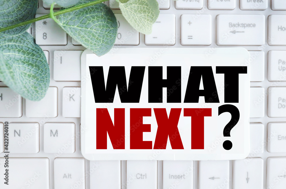 Poster what's next. text on white notepad paper on white keyboard.