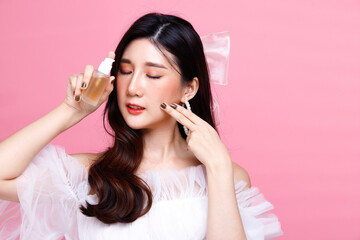 Portrait of Asian girl wear pink dress over pink tone background