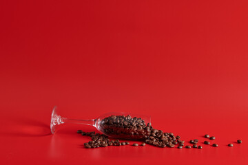 wine glass and grains of coffee on a red background