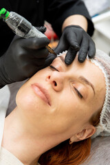 Cosmetologist doing permanent makeup eyebrows. Care and beauty concept