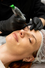 Cosmetologist doing permanent makeup eyebrows. Care and beauty concept