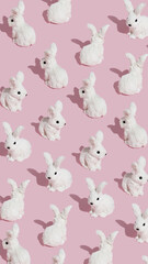 Pattern made with white bunnies on pastel pink background. Minimal Easter concept. Creative abstract layout.