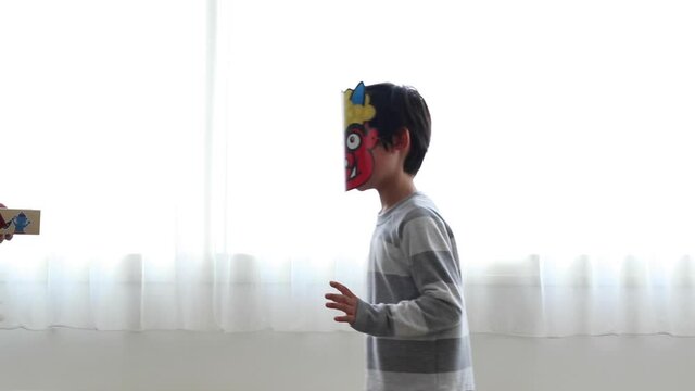節分でお面を被って鬼の役をする男の子