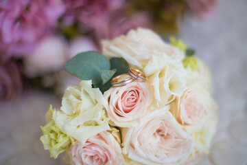 wedding rings on a wedding bouquet of roses