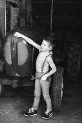 Obraz na płótnie Canvas little boy with tool repairs tractor