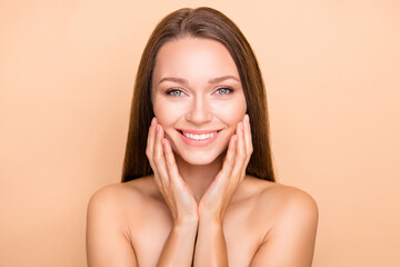 Portrait of pretty cheerful girl touching soft shine skin domestic procedure isolated over beige pastel color background