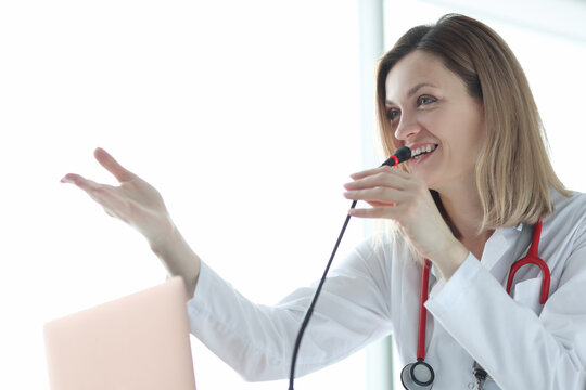 Woman doctor speaking into microphone at conference