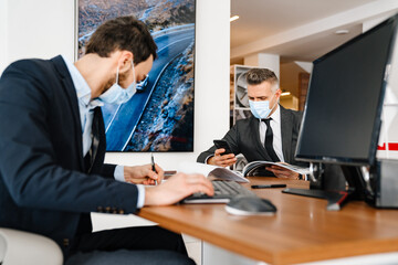 Mid unshaven manager working with mature customer in office