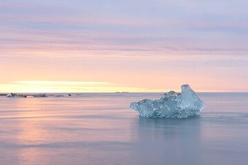 Ice floe in the water by the ocean at sunrise. glacial lagoon. Iceland. long exposure with blurry water.