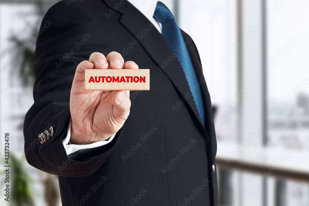 Poster businessman shows a wooden block with the word automation. automation systems in business