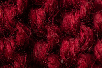 Knitted background of red, burgundy, wine color. Knitted texture. Knitting pattern from wool....