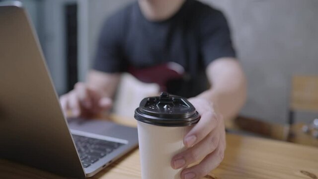 Front focus on white skin male hand grabbing paper cup of coffee during braking time, takeaway food or drink service, coronavirus illness prevention, work from home, caffeine empowering people, 