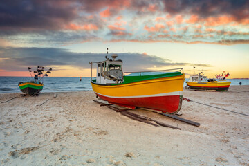 Amazing sunset with fishing boats at the beach of Baltic Sea in Sopot, Poland