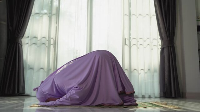 Muslim women praying In the foyer of the house during the coronavirus (COVID-19) outbreak, quarantine concept.