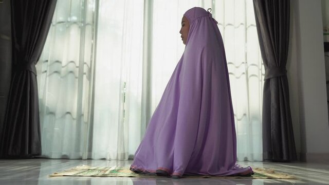 Muslim women praying In the foyer of the house during the coronavirus (COVID-19) outbreak, quarantine concept.