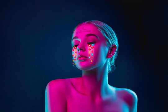Tears illustrated of social media activity signs on female face in neon light. Real life versus online lifestyle, addiction to modern technologies