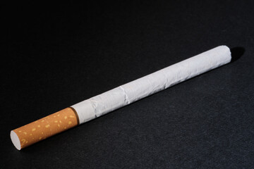 Close-up of a filter cigarette on a dark background. Selective focus. Minimal design with copy space