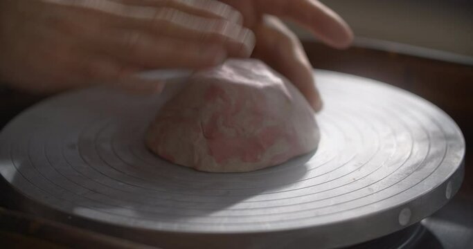 Potter puts colored clay to the potter's wheel for sculpting ceramics in nerikomi style, neriage ceramics, potter makes ceramics in slow motion, 4k 60p Prores HQ 10 bit