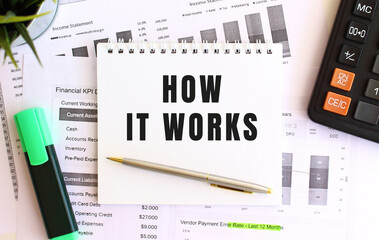 Notepad with text HOW IT WORKS on a white background, near marker, calculator.