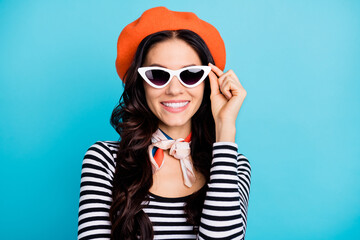 Photo of young cheerful girl happy positive smile hands touch sunglass wear beret isolated over blue color background