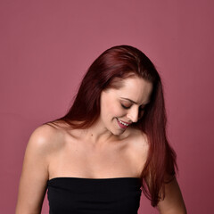 Naklejka premium close up portrait of red haired women with different facial expressions on a pink studio background.