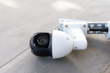 a rotary video camera for street surveillance lies on the ground ready for installation