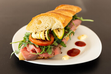 Bar sandwich with roast beef, grilled zucchini, tomato, rocket, ketchup