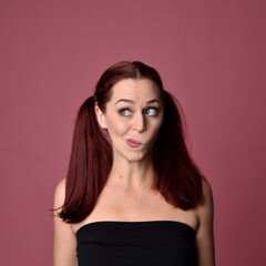 Naklejka premium close up portrait of red haired women with different facial expressions on a pink studio background.