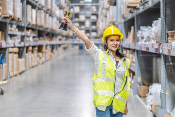 Happy woman warehouse worker holding a trophy after being selected as an outstanding employee