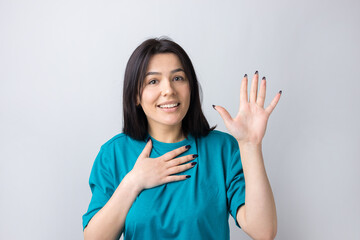 Young beautiful woman with facial expression of surprise standing over gray background.