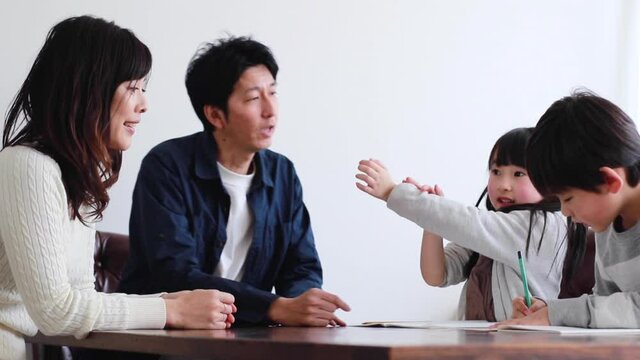 子供たちに勉強を教える両親