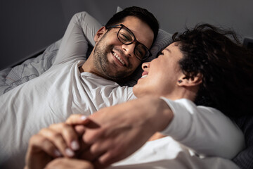 Obraz premium Beautiful couple laying on bed enjoying time together.