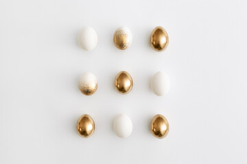 Golden eggs on a white background. Minimal easter concept.