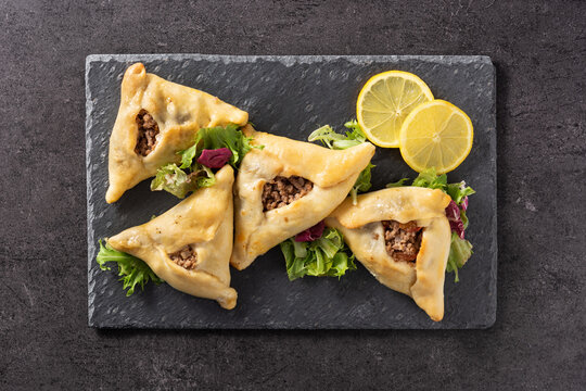 Traditional middle eastern fatayer on black slate.Top view