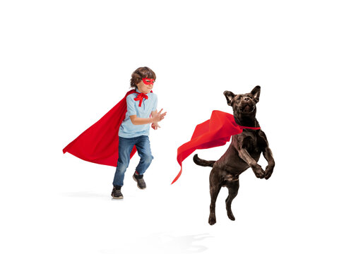 Child pretending to be a superhero with his super dog isolated on white studio background