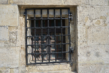 Fototapeta na wymiar lattice in the dungeon,black metal lattice in a medieval castle from the street