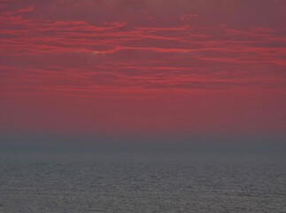  Soft blending of pastel colors over the ocean and the cloudy sky, very peaceful scene.