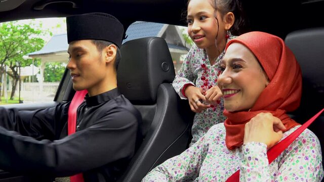 Malay family inside the car wearing traditional costume for Hari Raya festive