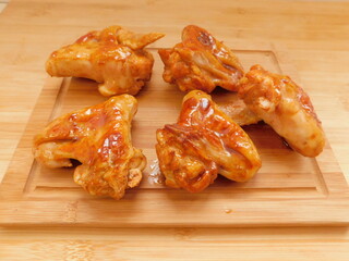 Buffalo BBQ Chicken Wings on wooden table.