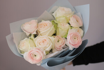 Young woman florist holding big beautiful blossoming mono bouquet of peach ranunculus clooney hanoi flowers.
