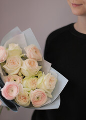 Young woman florist holding big beautiful blossoming mono bouquet of peach ranunculus clooney hanoi flowers.