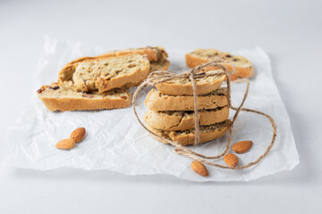 Fototapeta na wymiar А stack of cookies tied with eco rope and blurred cookies on background. Italian biscotti cookies on baking paper. Classic recipe