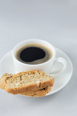 A cup of coffee with Italian biscotti cookie. Top view fresh baked cookie with white cup of coffee. Copy space. Vertical orientation. Classic pecipe