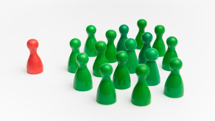 Rote Spielfigur wird von grünen Spielfiguren ausgegrenzt - Ausgrenzung - Symbolbild