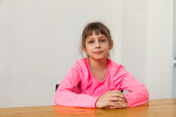 Naklejka premium Young 8 year old girl portrait in front of white wall