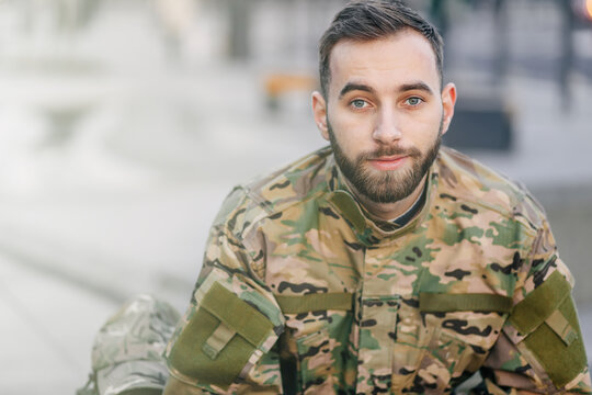 a young army soldier is smiling, a military man in a camouflage